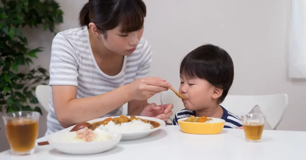 カレーを食べさせるお母さん